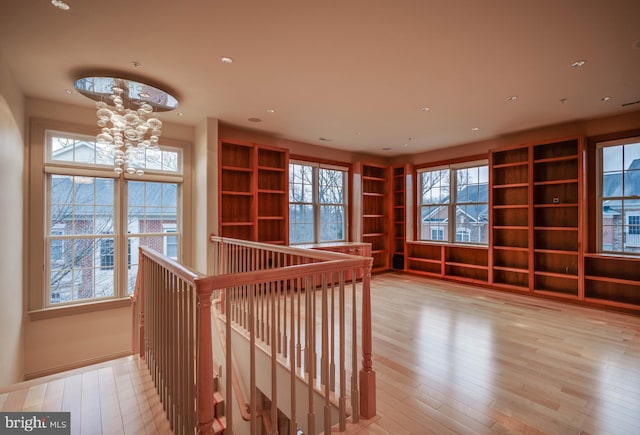 interior space featuring an inviting chandelier, light hardwood / wood-style flooring, and plenty of natural light