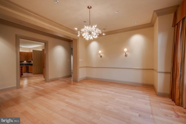 unfurnished room with a notable chandelier, ornamental molding, and light hardwood / wood-style floors