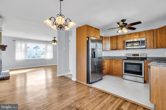 kitchen with hanging light fixtures, light hardwood / wood-style floors, stainless steel appliances, and ceiling fan with notable chandelier