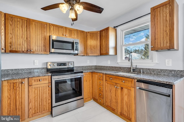 kitchen featuring sink, appliances with stainless steel finishes, ceiling fan, and light tile patterned floors