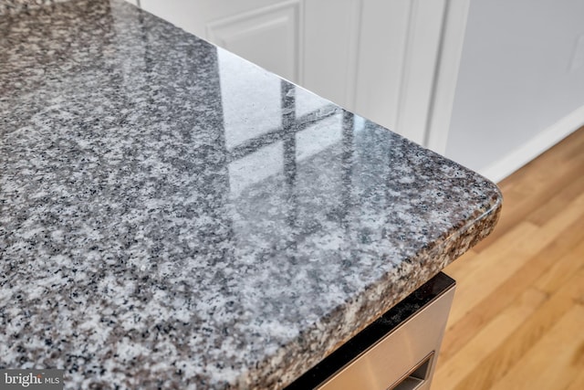 interior details featuring dark stone countertops and wood-type flooring