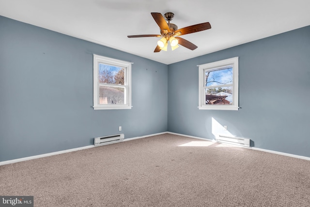 carpeted empty room with ceiling fan, a baseboard heating unit, and a healthy amount of sunlight