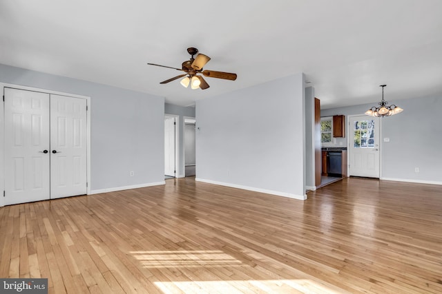 unfurnished living room featuring ceiling fan with notable chandelier and light hardwood / wood-style flooring