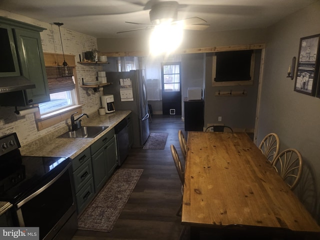 kitchen with a wealth of natural light, decorative light fixtures, sink, stainless steel appliances, and dark wood-type flooring