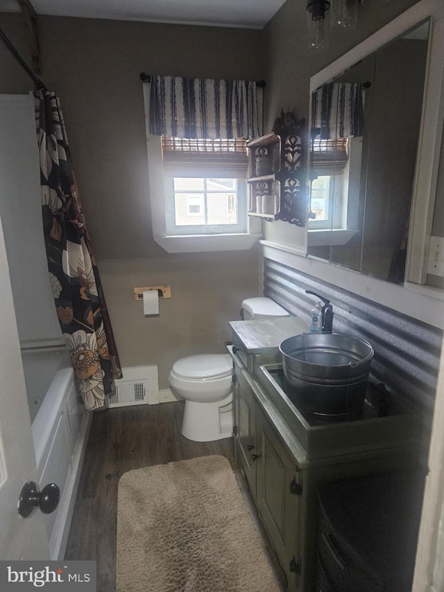 full bathroom with hardwood / wood-style flooring, vanity, toilet, and shower / tub combo