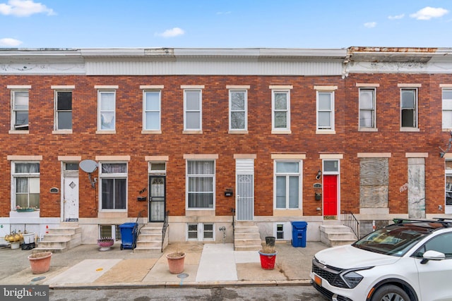 townhome / multi-family property with entry steps and brick siding