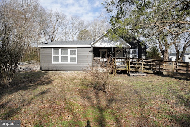 view of front of property featuring a wooden deck and a front lawn