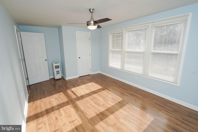 unfurnished bedroom featuring hardwood / wood-style flooring, ceiling fan, and a closet