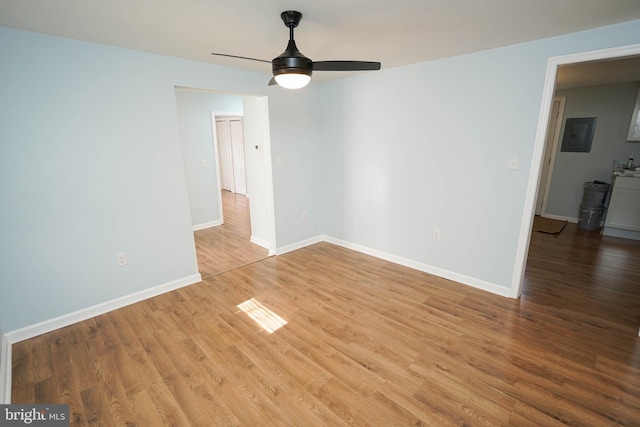 spare room featuring light hardwood / wood-style flooring, electric panel, and ceiling fan