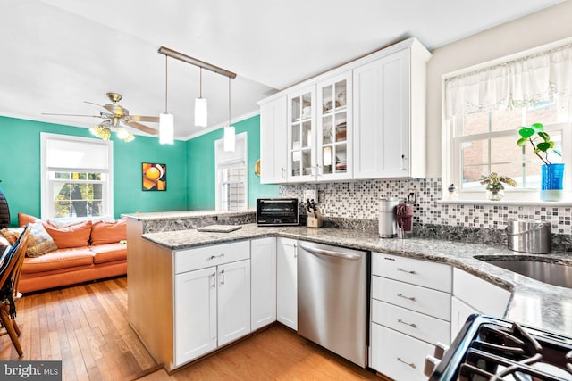 kitchen with backsplash, stainless steel appliances, light stone counters, white cabinets, and kitchen peninsula