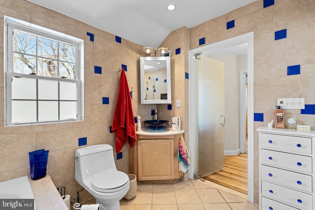 bathroom with vanity, tile walls, tile patterned floors, and toilet