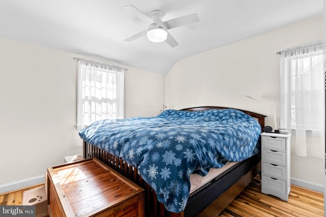 bedroom with hardwood / wood-style flooring, vaulted ceiling, and ceiling fan