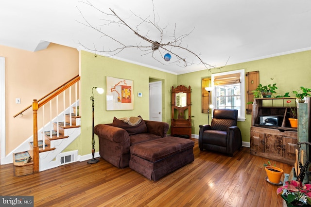 living room featuring ornamental molding and wood-type flooring