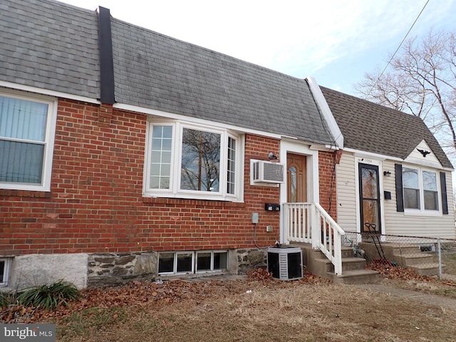 view of front of property featuring a wall mounted AC and central AC