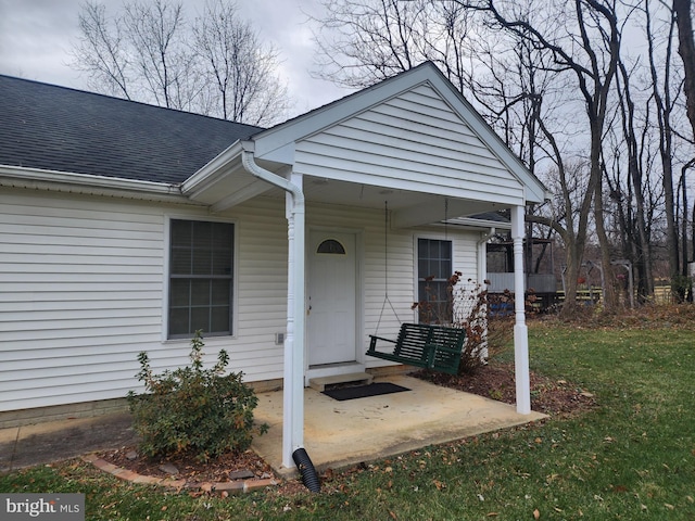 doorway to property featuring a lawn and a patio