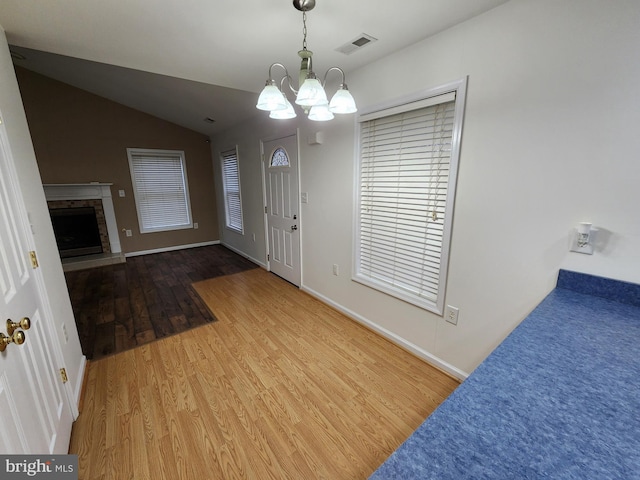 foyer featuring a chandelier, wood-type flooring, and lofted ceiling