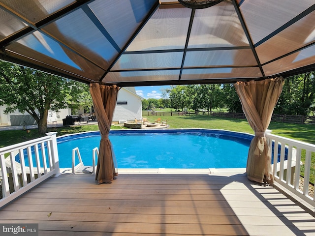 view of swimming pool with a gazebo, a wooden deck, and a lawn