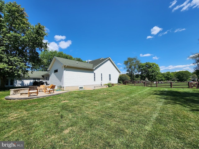 view of side of home with a patio and a yard