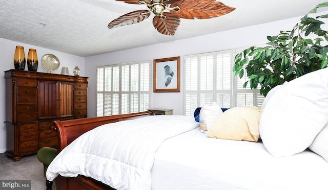 bedroom featuring ceiling fan, carpet, and a textured ceiling