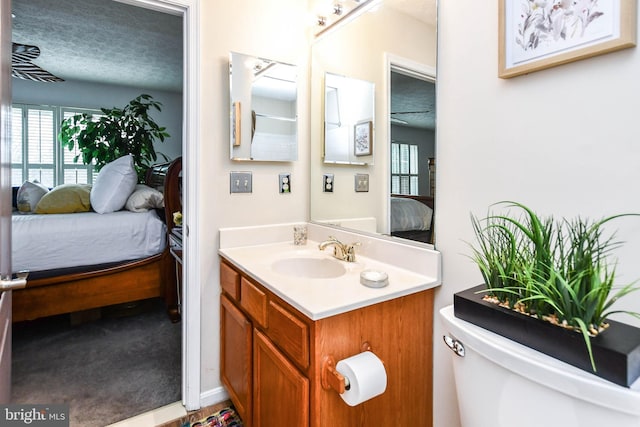 bathroom featuring vanity, a textured ceiling, and toilet