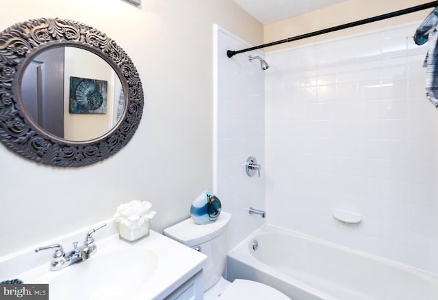 full bathroom featuring vanity, tiled shower / bath, and toilet