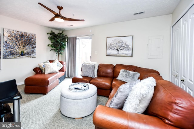 carpeted living room with ceiling fan, electric panel, and a textured ceiling