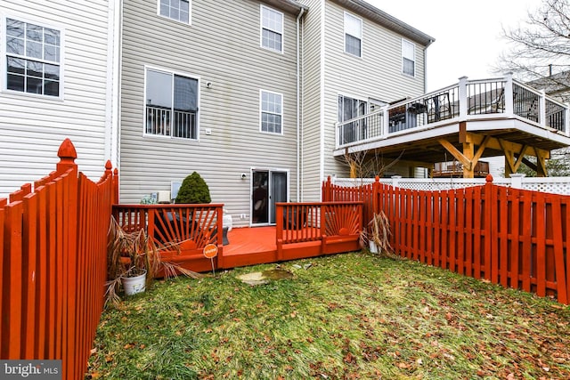 back of property featuring a yard and a deck