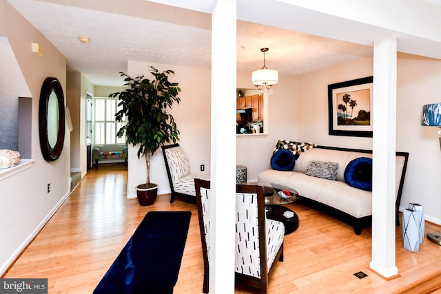 living room with a notable chandelier and light hardwood / wood-style flooring