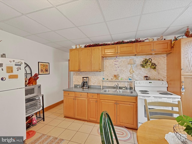 kitchen featuring light tile patterned flooring, sink, a paneled ceiling, white appliances, and decorative backsplash