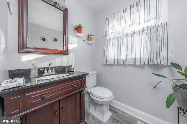 bathroom featuring hardwood / wood-style flooring, vanity, and toilet