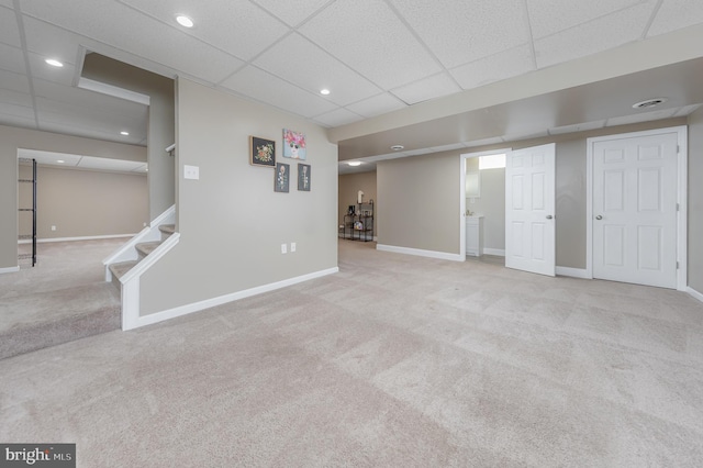 basement with light carpet and a drop ceiling