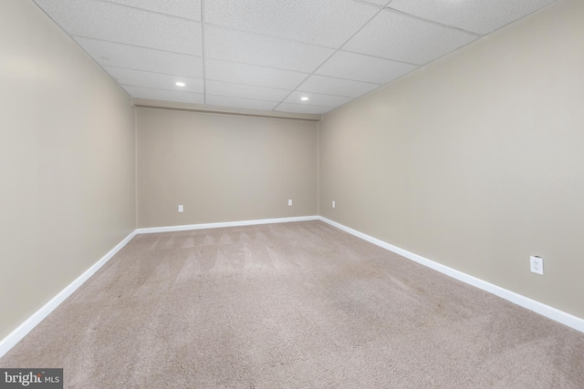 carpeted spare room with a drop ceiling