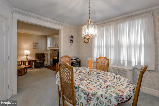 dining area featuring an inviting chandelier, radiator heating unit, ornamental molding, light colored carpet, and a fireplace