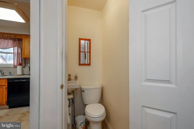 bathroom featuring sink, decorative backsplash, and toilet