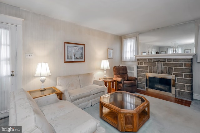 living room featuring carpet flooring and a stone fireplace