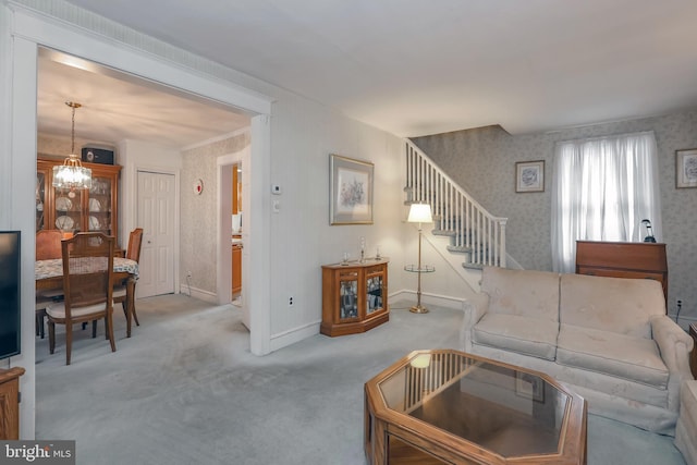 carpeted living room featuring an inviting chandelier