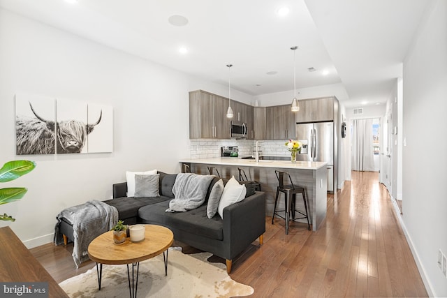 living room featuring sink and hardwood / wood-style floors