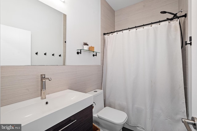 bathroom with vanity, tile walls, and toilet