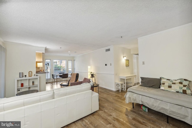 living room with crown molding, hardwood / wood-style floors, and a textured ceiling