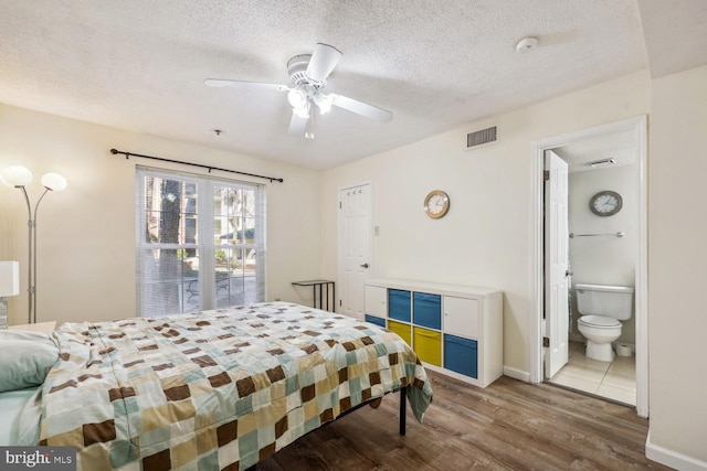 bedroom with wood-type flooring, ensuite bathroom, ceiling fan, and a textured ceiling