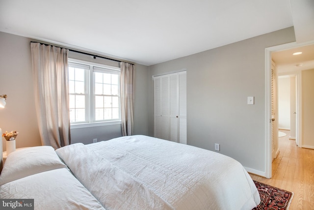 bedroom with light wood-type flooring and a closet