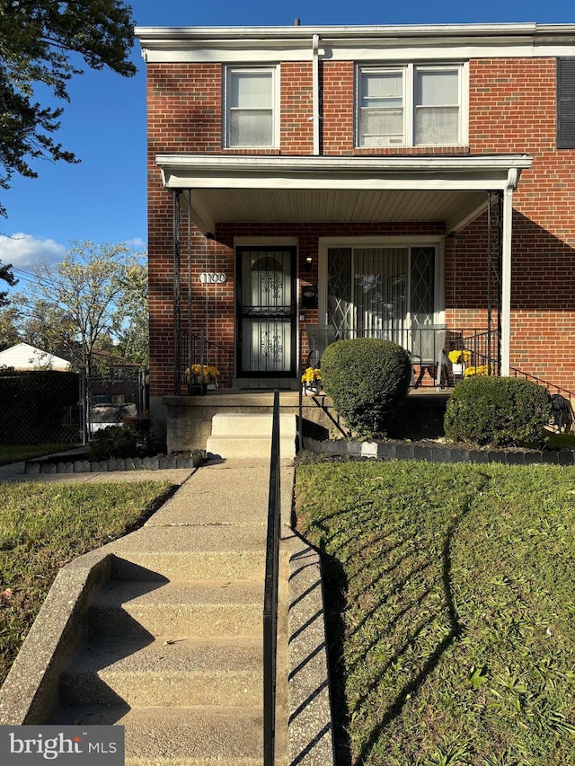 view of front facade featuring brick siding and a porch