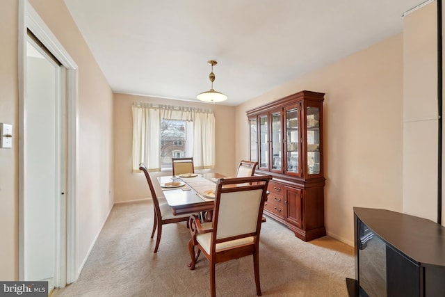 dining room with light colored carpet and baseboards