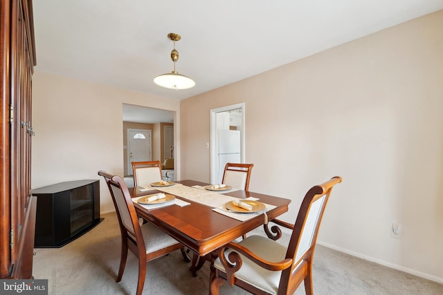 dining area with light colored carpet and baseboards