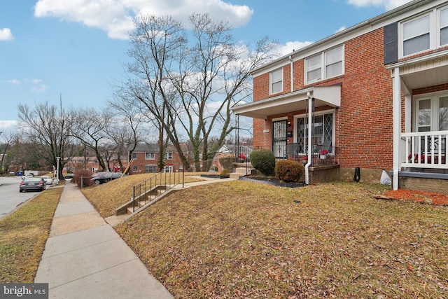 view of home's exterior featuring a porch and a lawn