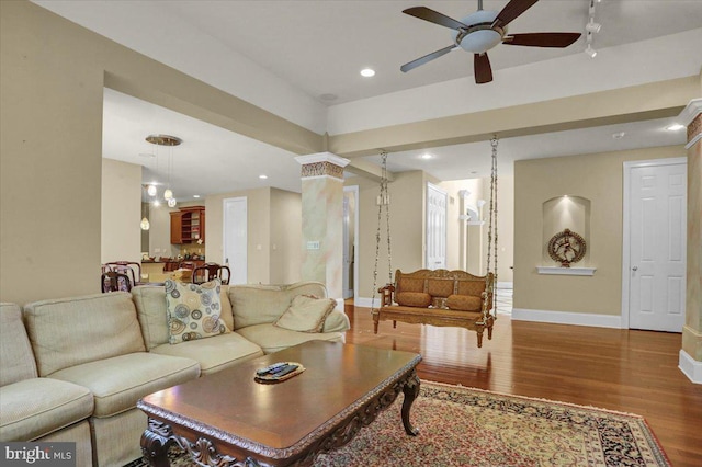 living room featuring hardwood / wood-style flooring, ceiling fan, and ornate columns