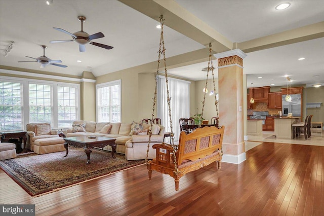 living room with decorative columns and light hardwood / wood-style flooring