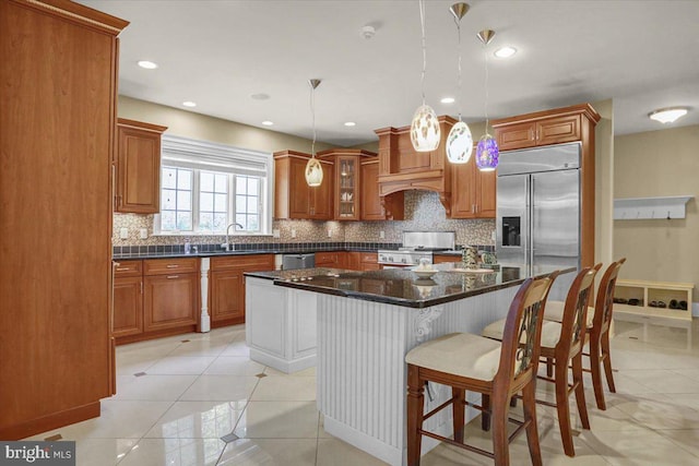 kitchen featuring light tile patterned flooring, sink, a center island, pendant lighting, and stainless steel appliances