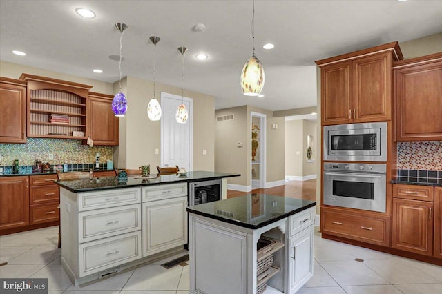 kitchen with stainless steel appliances, a kitchen island, pendant lighting, and light tile patterned floors