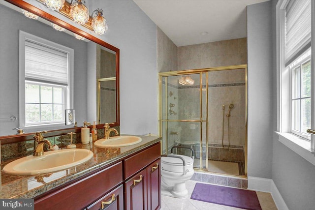 bathroom with vanity, a wealth of natural light, a shower with door, and toilet